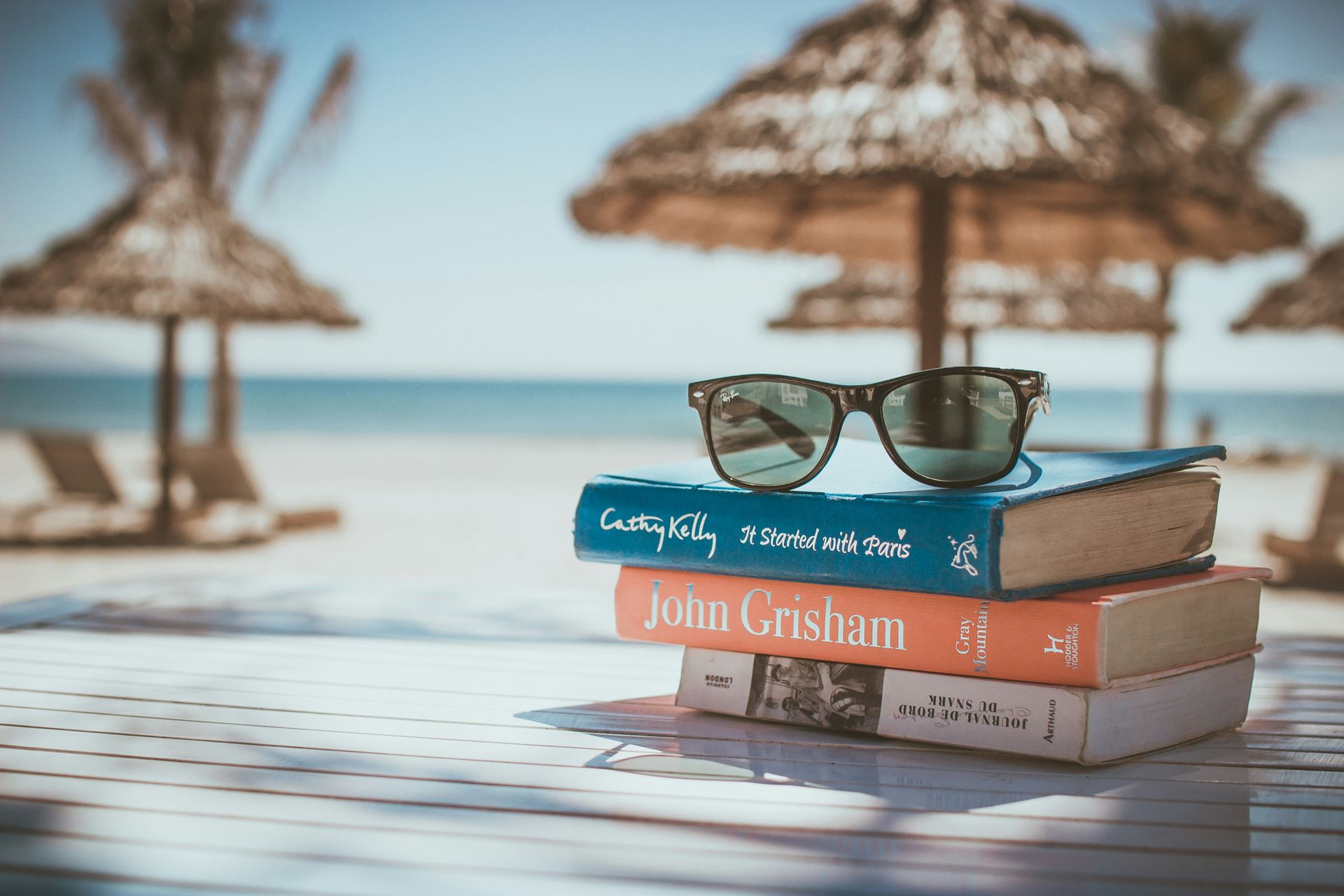 Beach scene with books and sunglasses. 